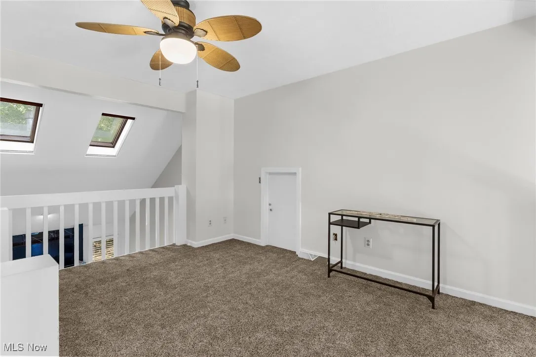 Bonus room with carpet floors, lofted ceiling, a skylight, and a ceiling fan