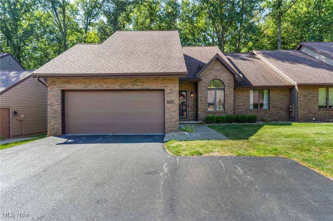 View of front facade featuring brick siding, roof with shingles, driveway, a 2 Car garage, and a front yard double parking