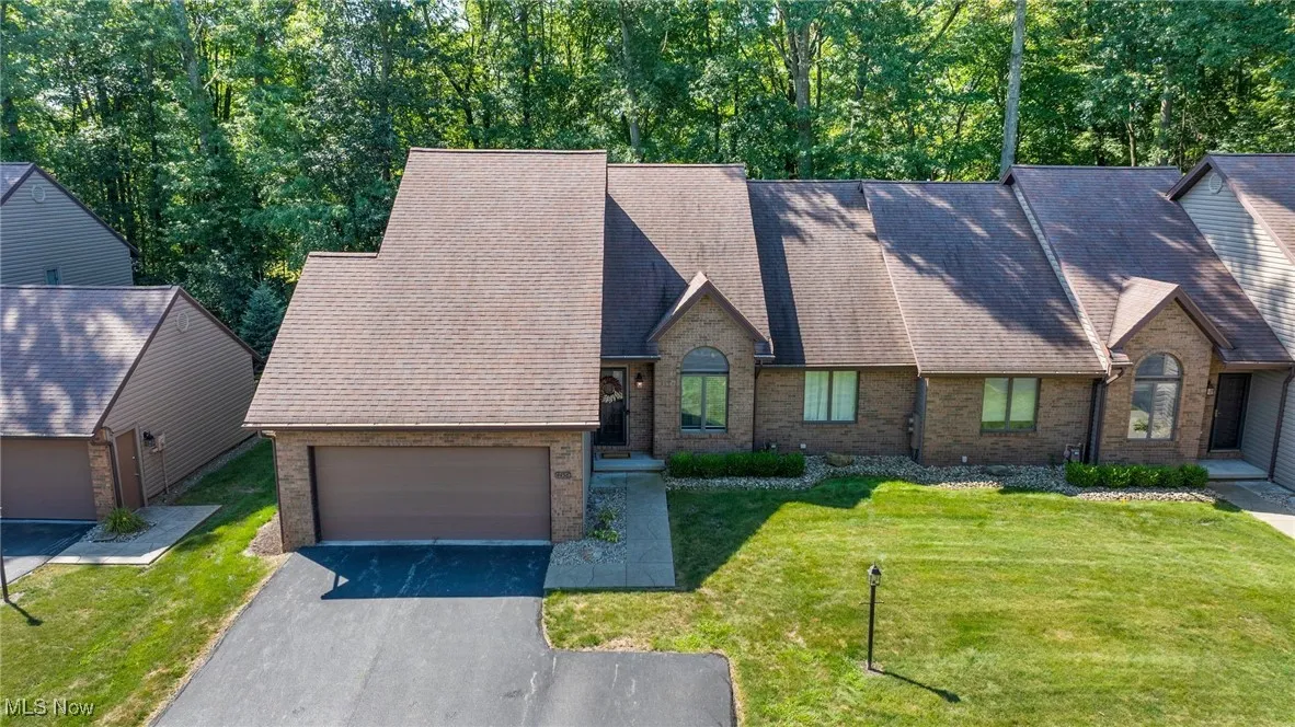 French country style house featuring brick siding, driveway, a front yard, and roof with shingles