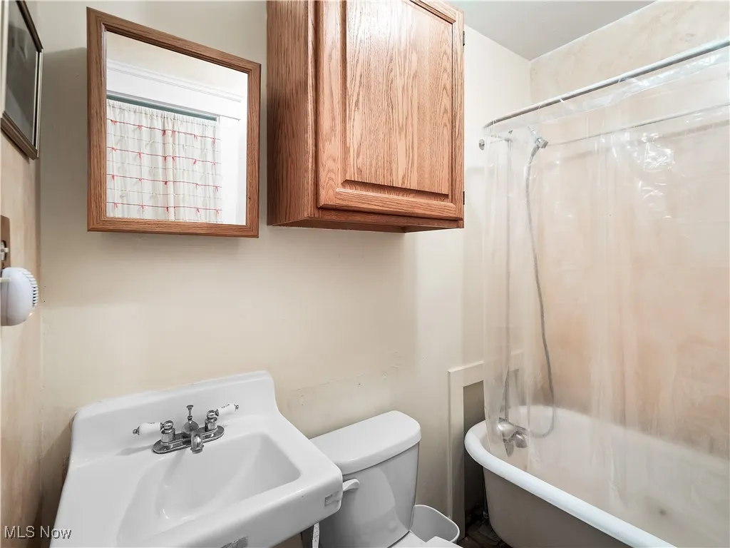 Bathroom featuring toilet and a combined bath / shower with clawfoot tub