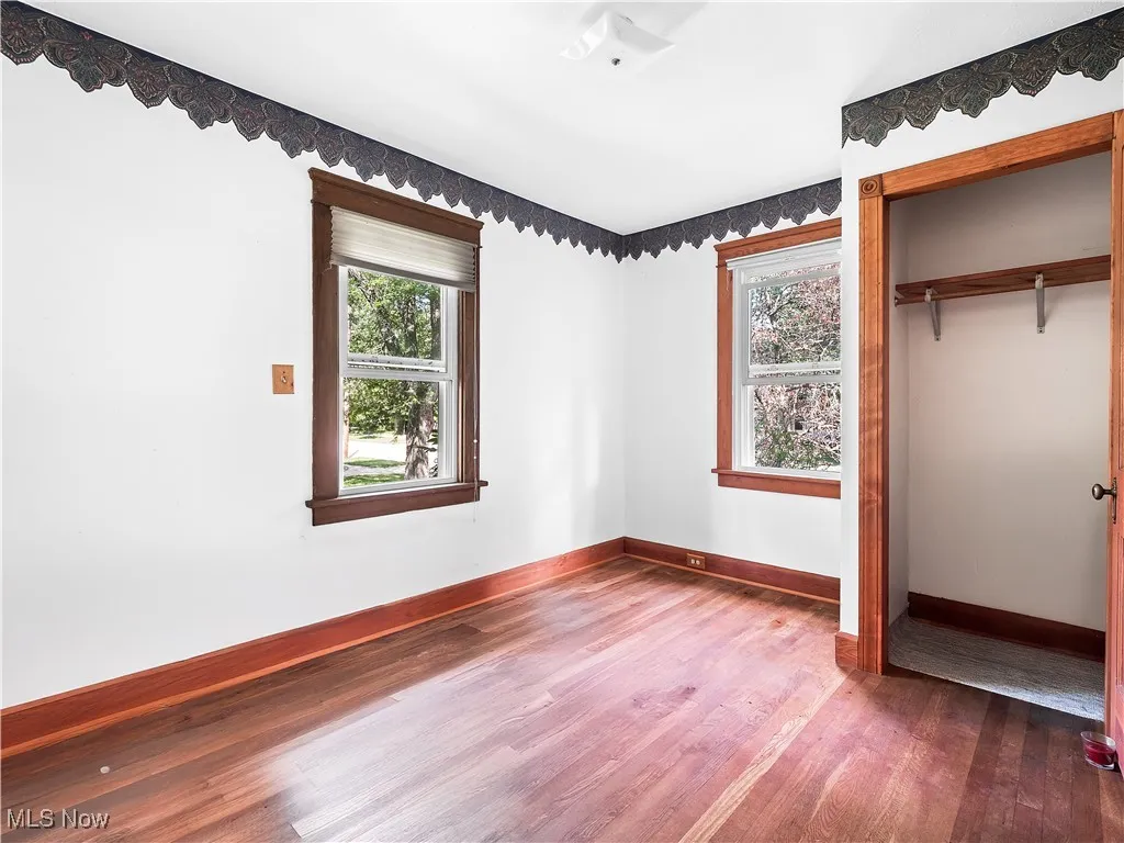 Unfurnished bedroom featuring hardwood floors and a closet