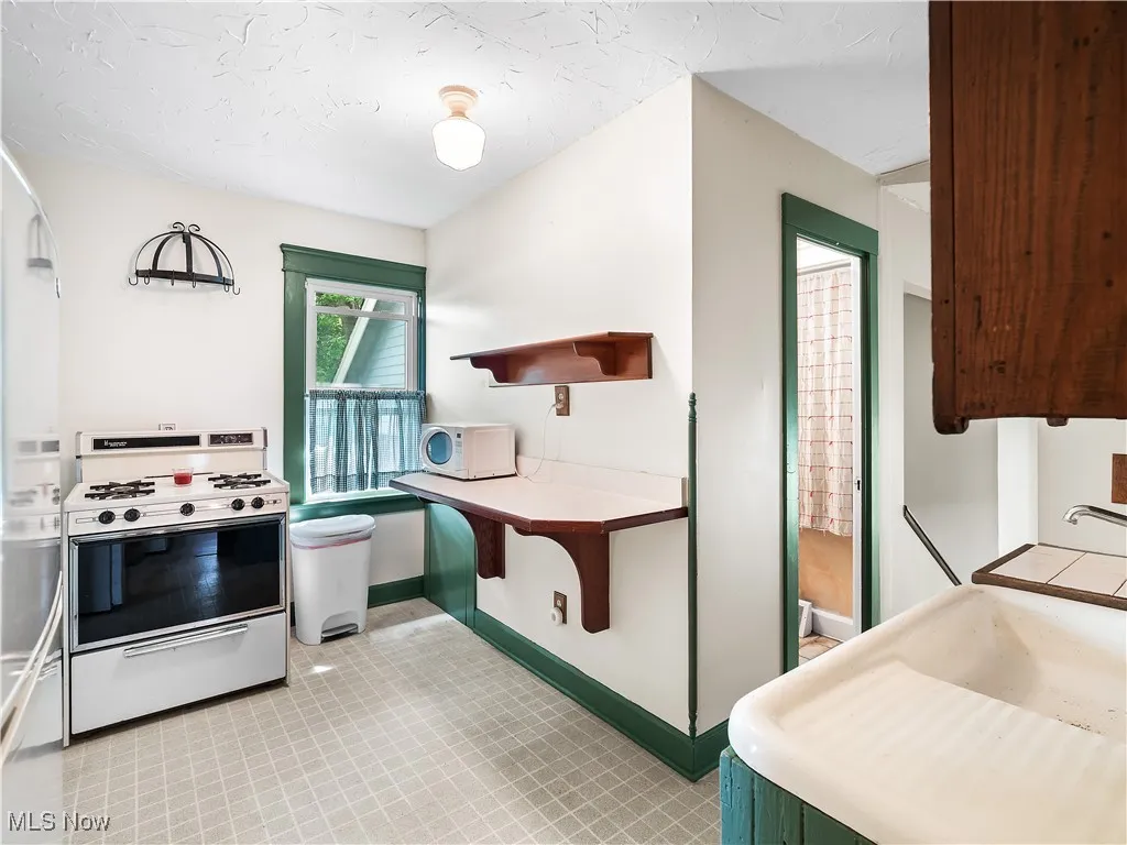 Kitchen with open shelves, white appliances, and light countertops