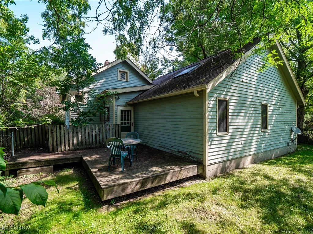 Back of house featuring a wooden deck and roof with shingles