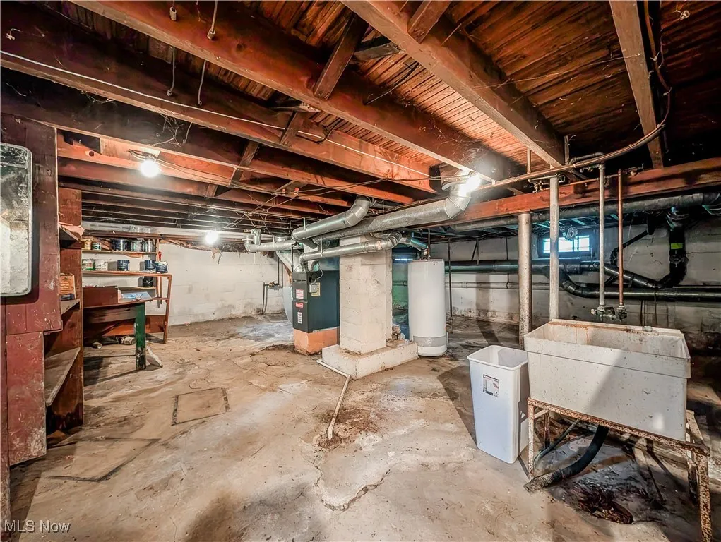 Unfinished basement featuring water heater and heating unit