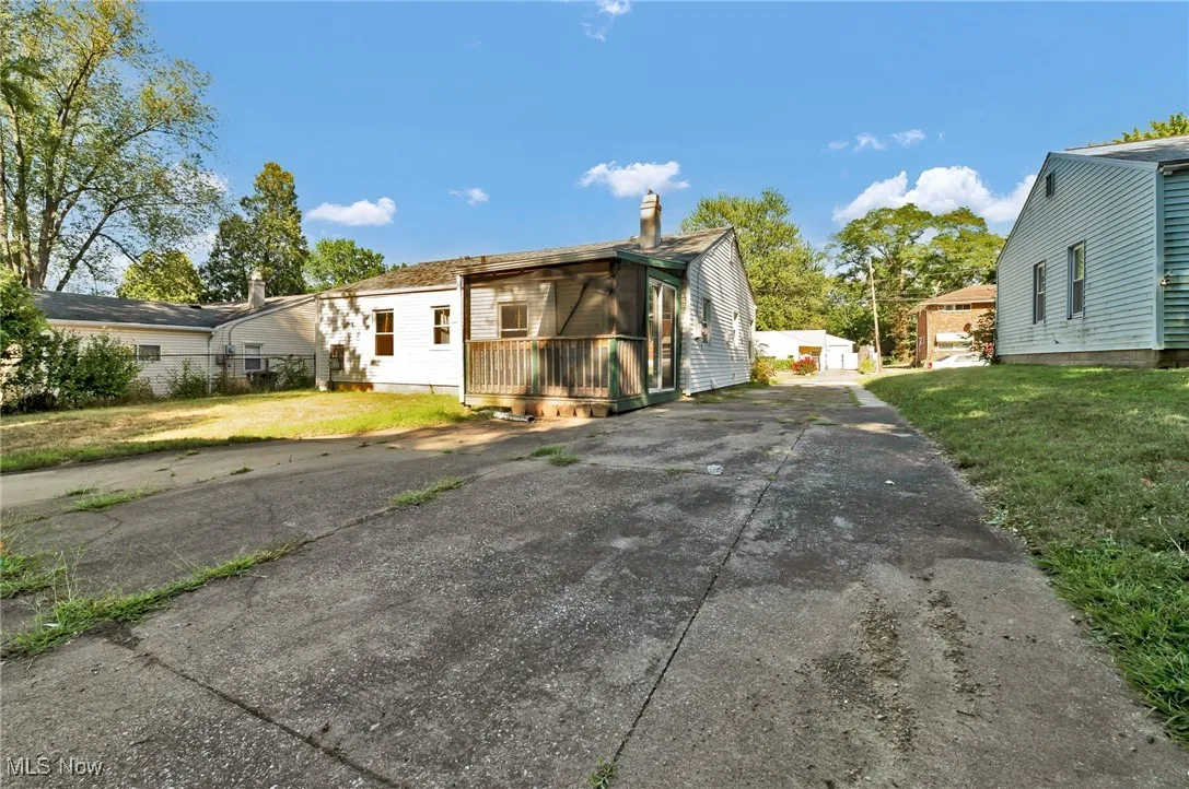 View of side of home featuring a lawn, an outdoor structure, and a chimney