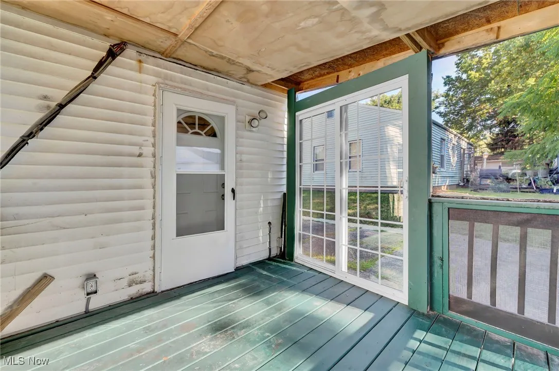 Unfurnished sunroom featuring a wooden deck