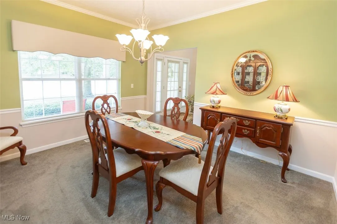 Dining room featuring crown molding, carpet floors and a chandelier