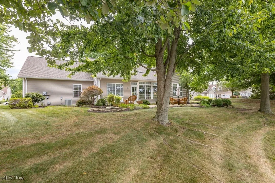 Back of property featuring a yard and roof with shingles