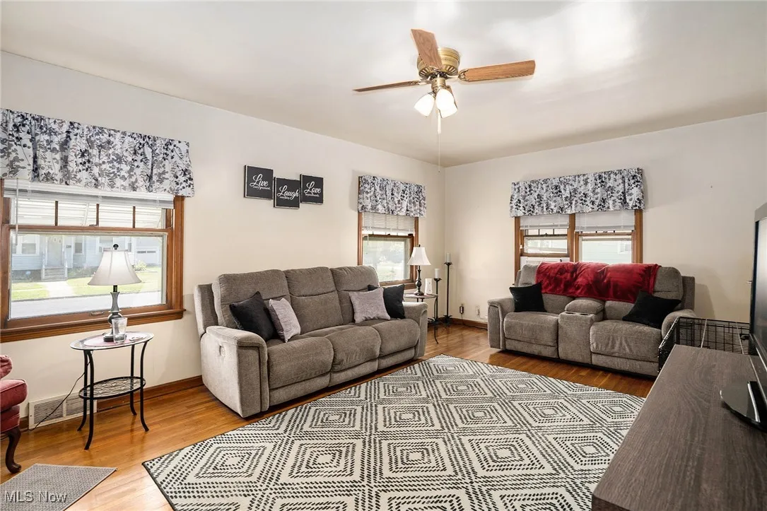 Living area with light wood-type flooring and ceiling fan