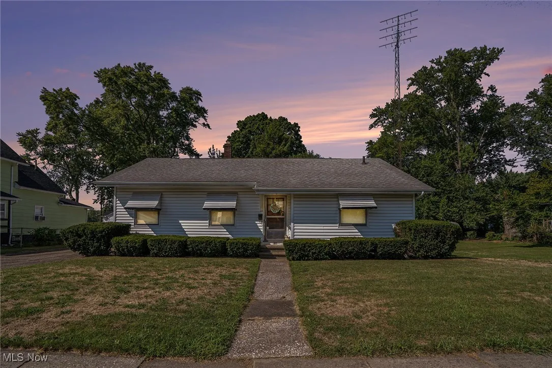 View of front of house featuring a front lawn and roof with shingles