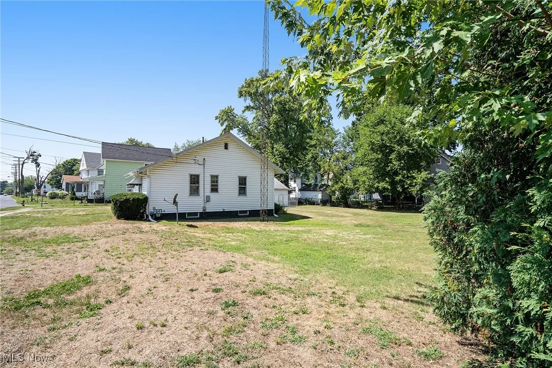 View of side of property with a lawn