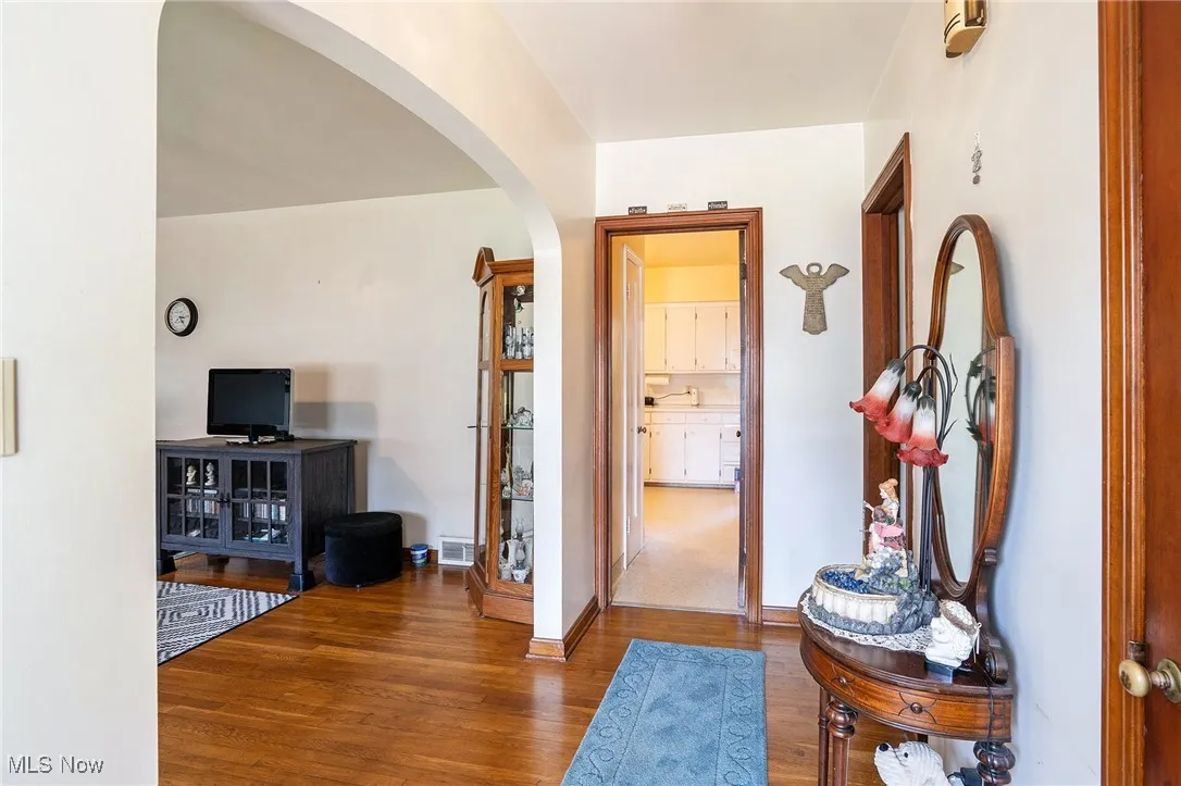 Foyer with wood finished floors and arched walkways