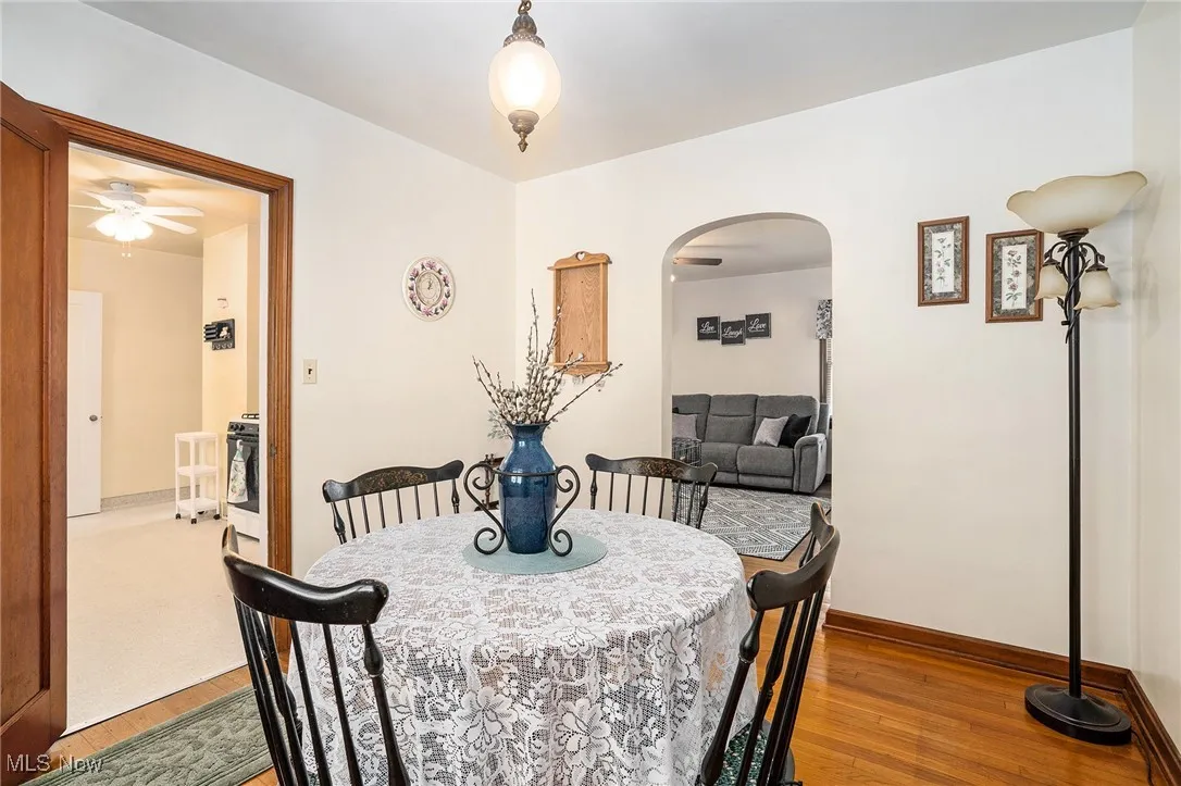 Dining space featuring wood finished floors and arched walkways
