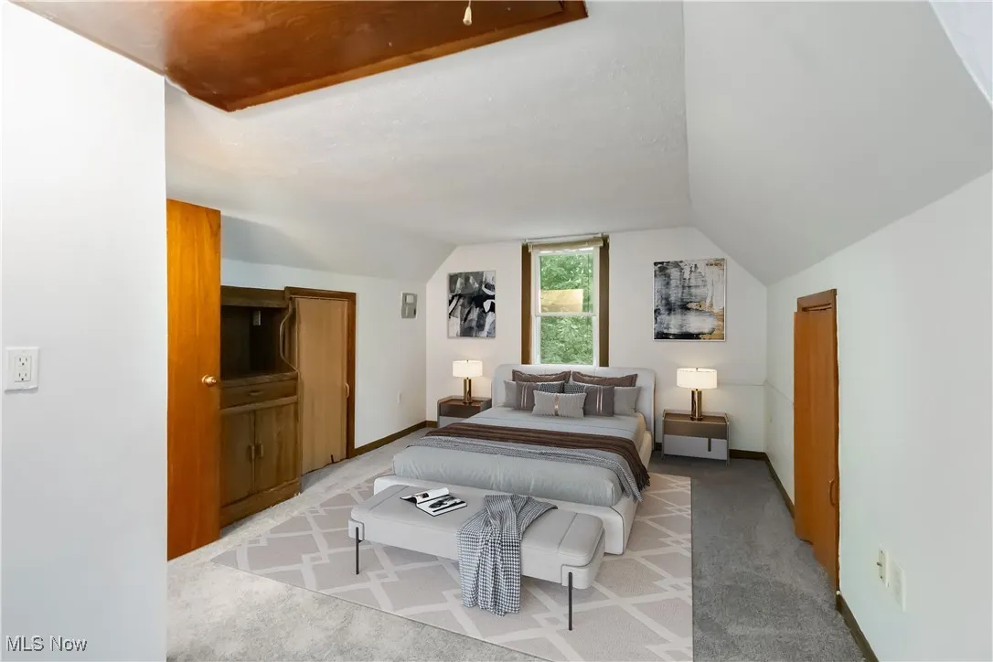 Bedroom with carpet and lofted ceiling