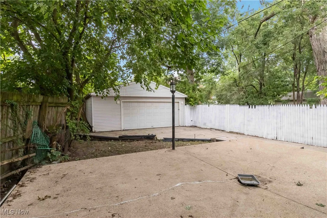 View of patio with an outdoor structure and a detached garage