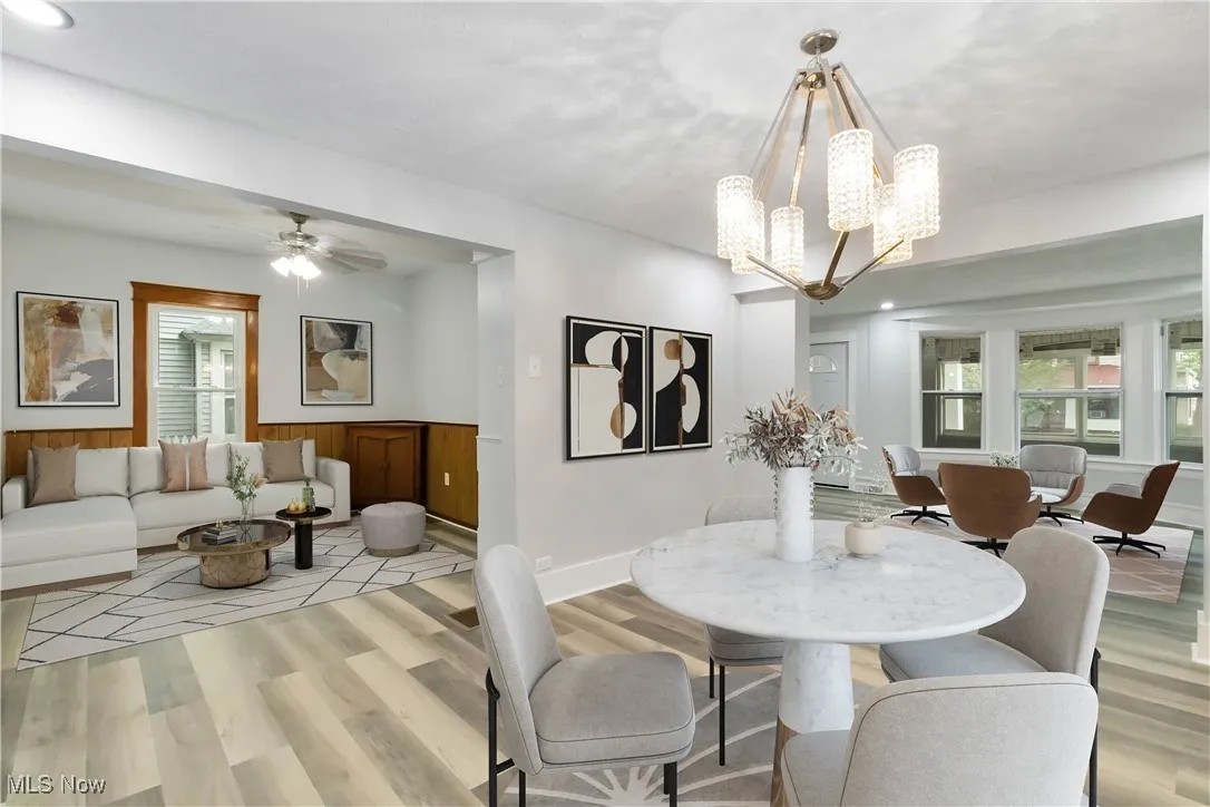 Dining area featuring light wood-style flooring, a chandelier, and a ceiling fan