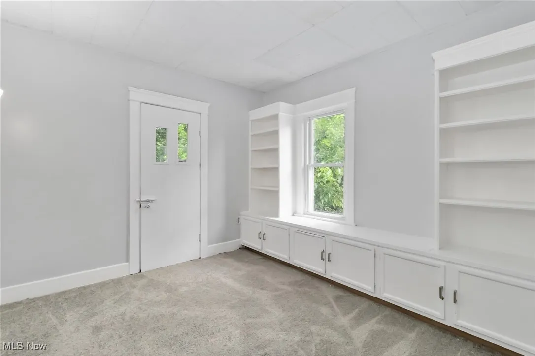 Empty room featuring plenty of natural light and light colored carpet