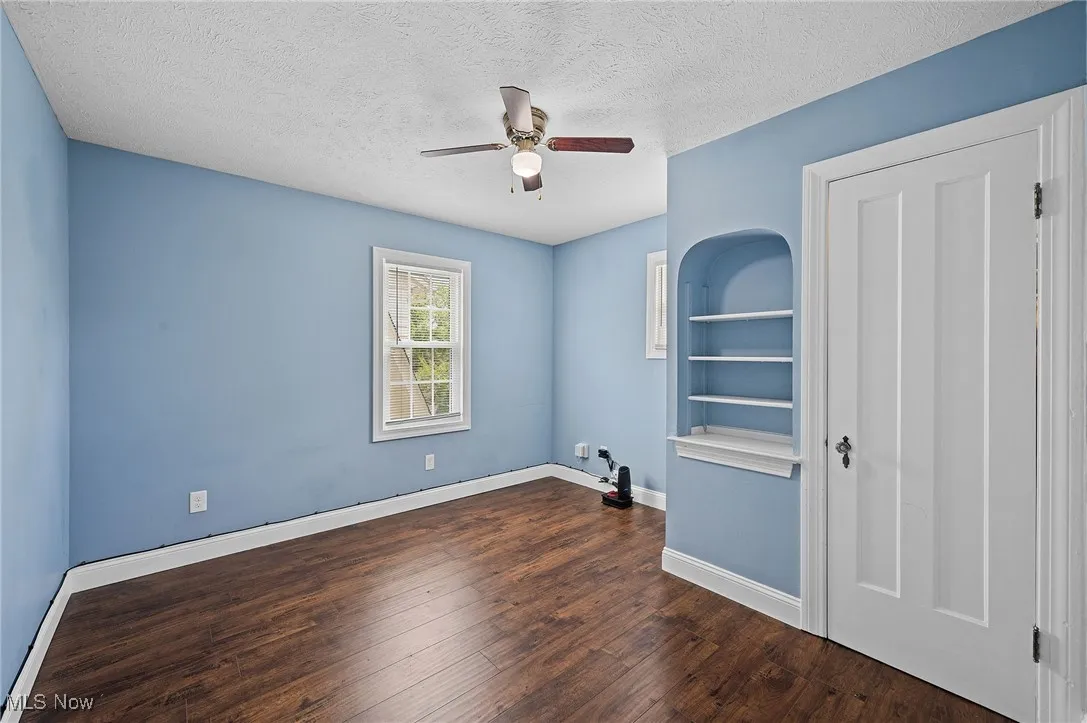 Bedroom 2 featuring dark wood finished floors, a textured ceiling, and a ceiling fan