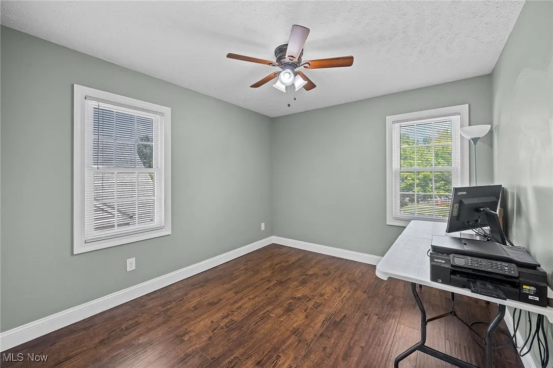 Bedroom 3, previously used as office featuring dark wood-style floors, a textured ceiling, and a ceiling fan