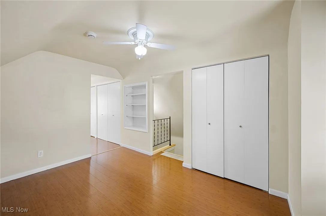 Additional third floor bedroom space featuring lofted ceiling, a baseboard radiator, and wood finished floors