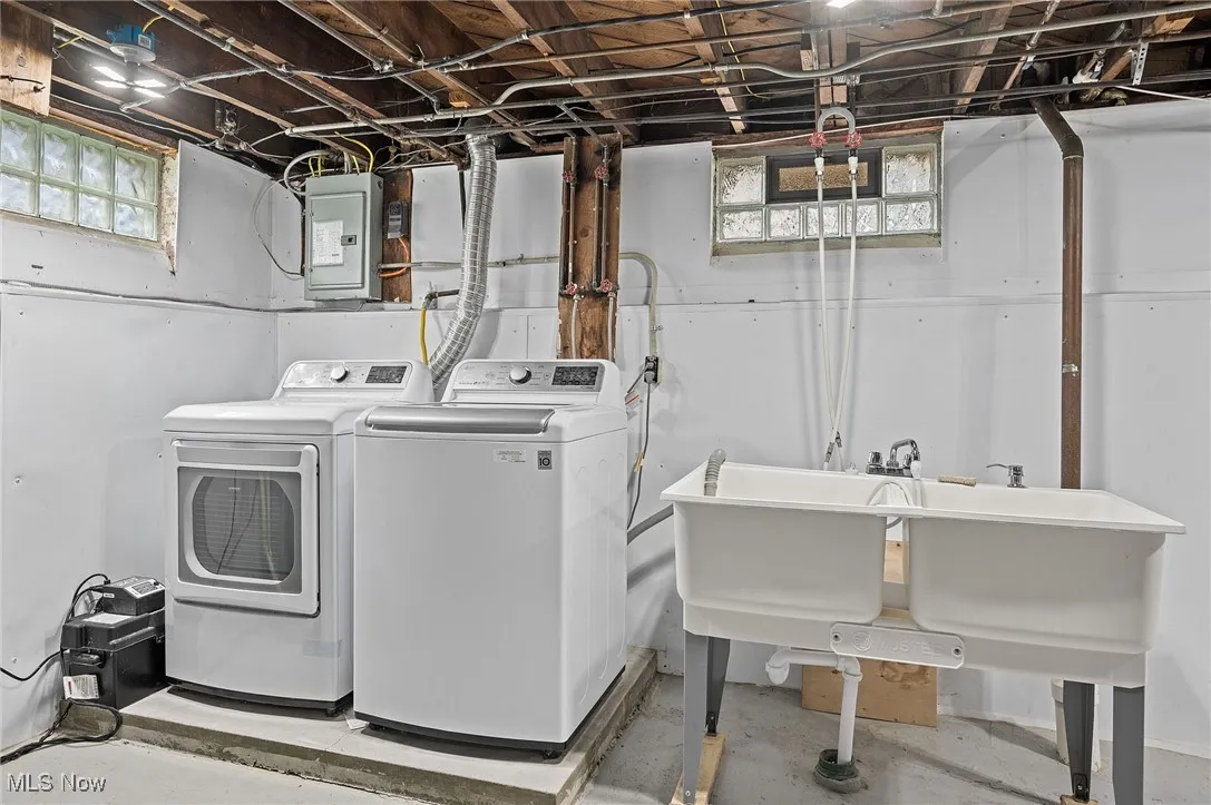 Washroom with washer and clothes dryer, electric panel, and healthy amount of natural light