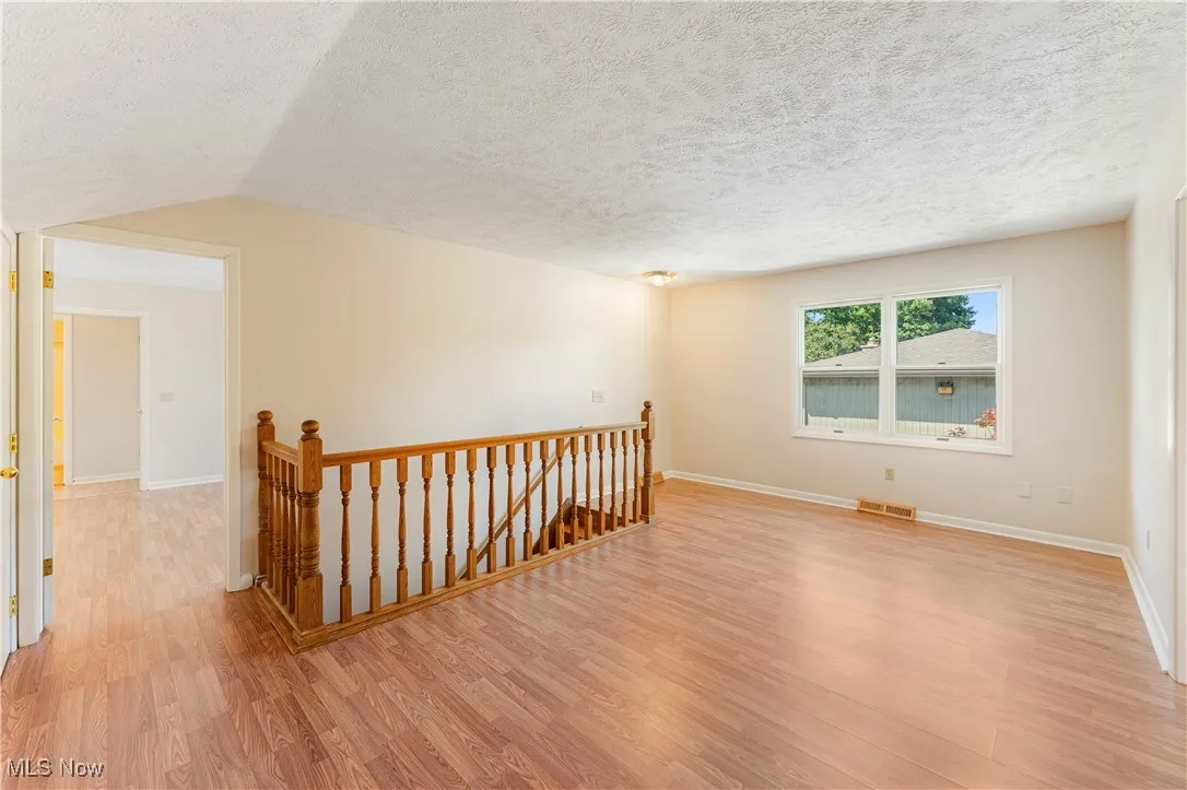 Spare room featuring light wood-style floors and a textured ceiling