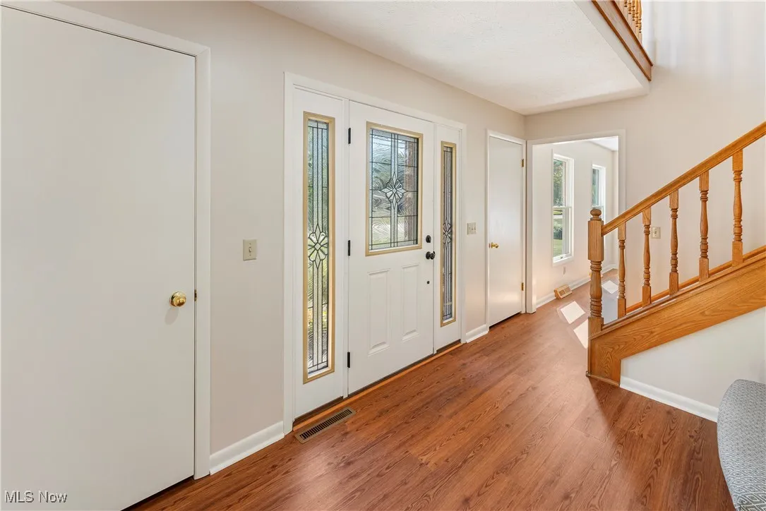 Foyer featuring wood look LVP floors and stairway