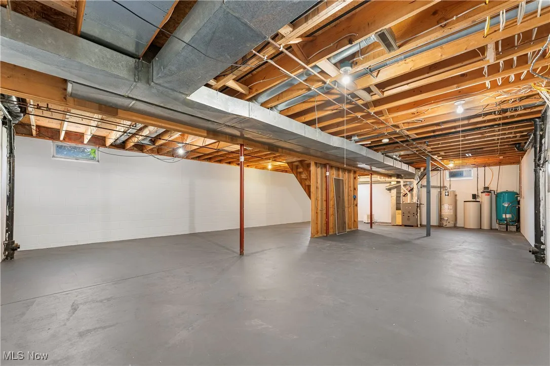 Below grade area with a water pressure tank, a water softener, and water heater