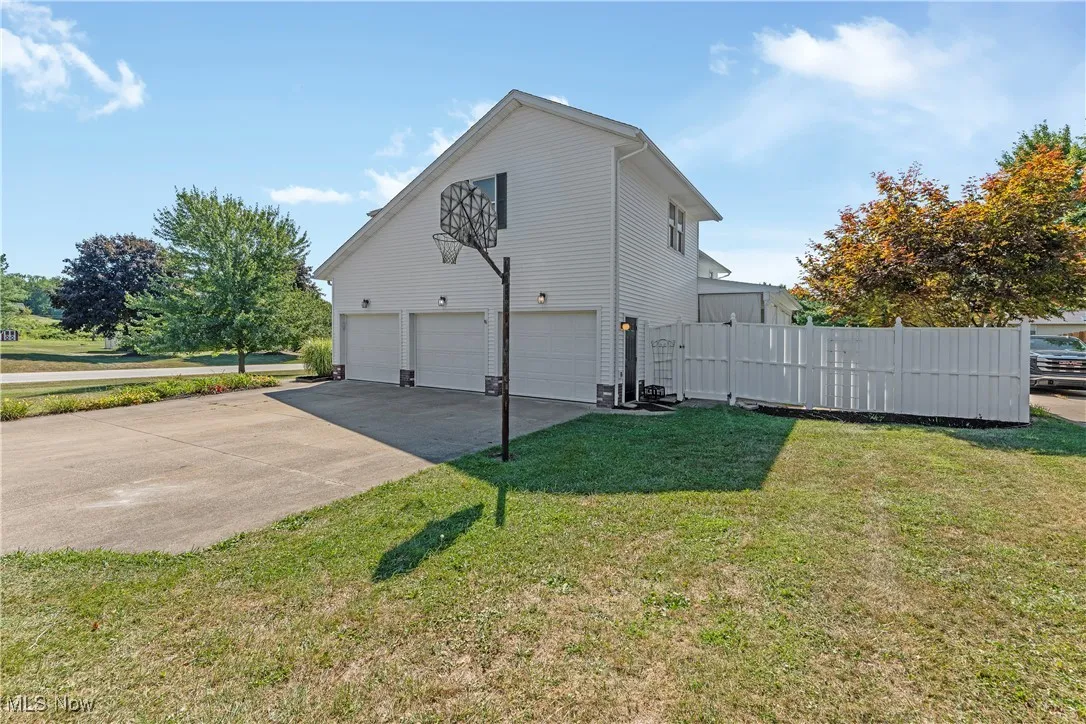 View of side of home with driveway , fence and a garage