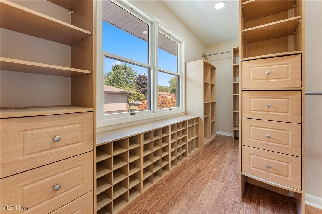 Walk in closet with light wood finished floors