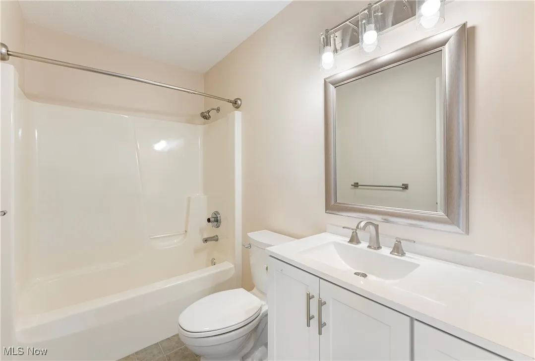 Full bathroom featuring vanity, bathtub / shower combination, and light tile patterned floors