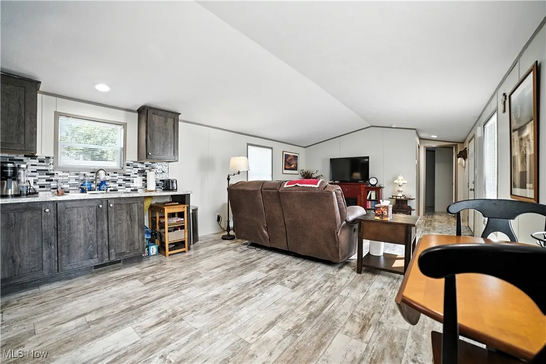 Living area featuring light wood-style floors and vaulted ceiling