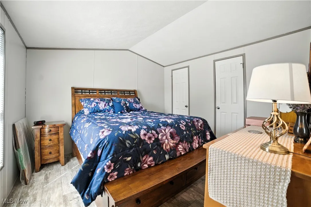 Bedroom featuring vaulted ceiling and wood finished floors