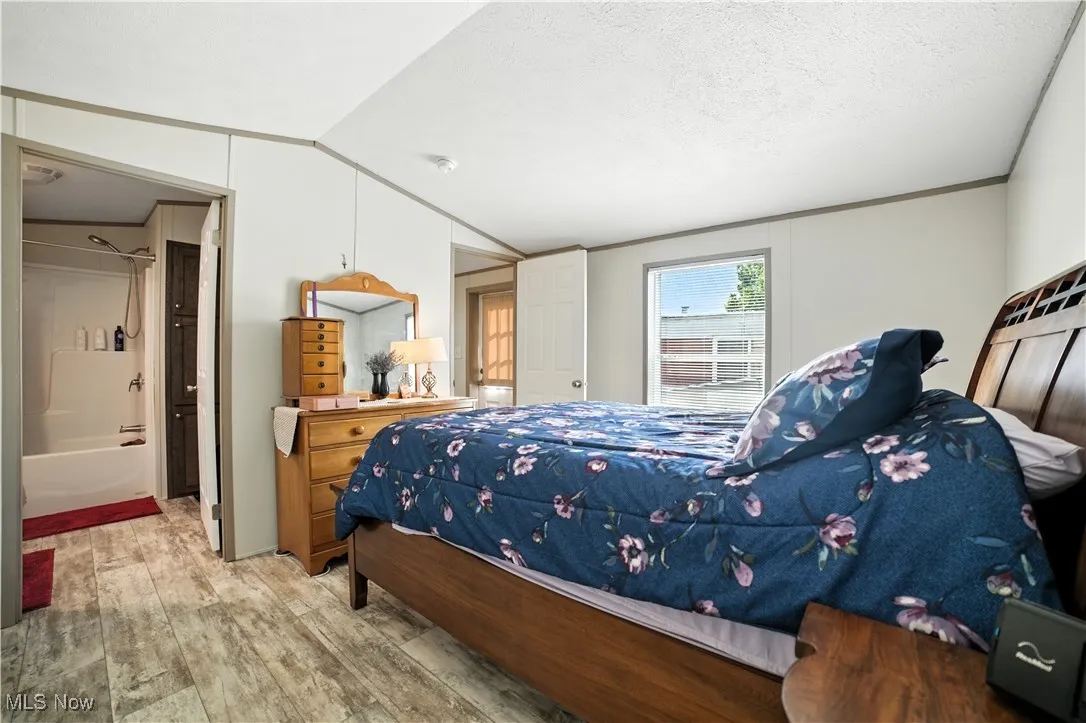 Bedroom featuring vaulted ceiling and light wood-style floors