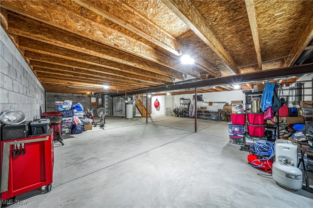 Unfinished below grade area featuring water heater