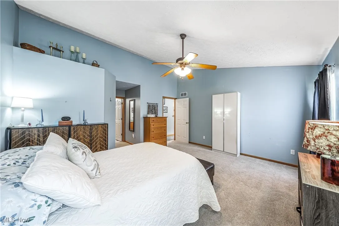 Bedroom featuring carpet flooring, ceiling fan, and high vaulted ceiling