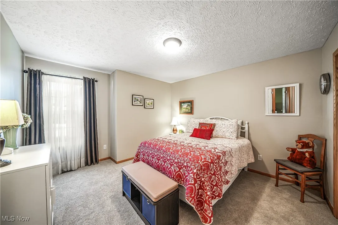 Bedroom with light carpet and a textured ceiling