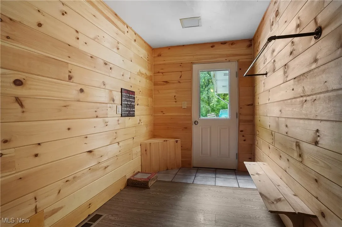 Mudroom with wooden walls and wood finished floors