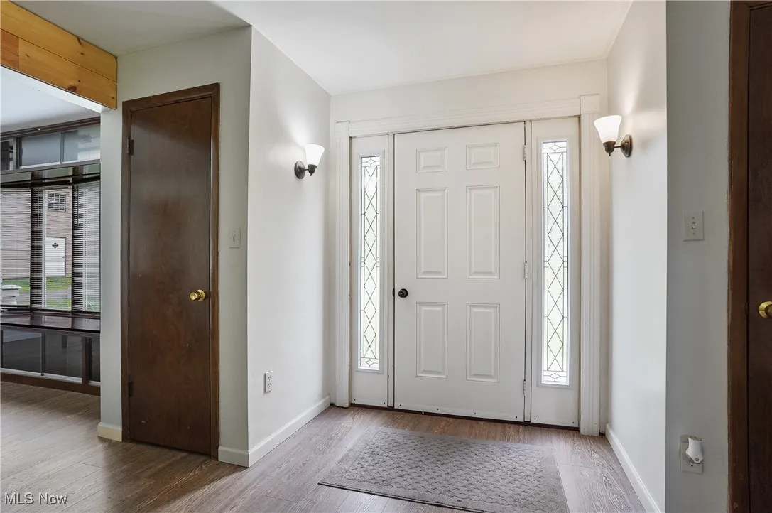 Foyer entrance with wood finished floors and baseboards