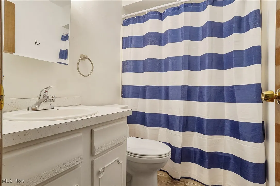 Full bath featuring vanity and curtained shower