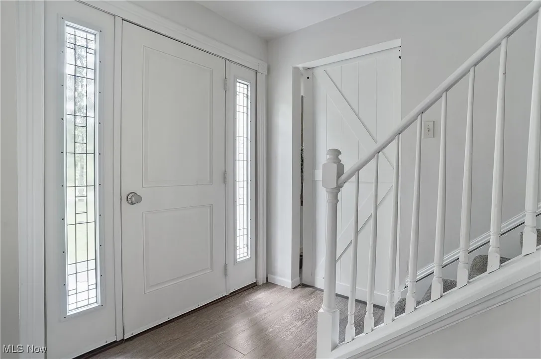 Entrance foyer with wood finished floors and stairway