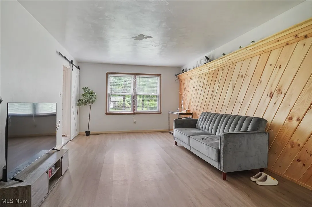 Living area with a barn door and wood finished floors
