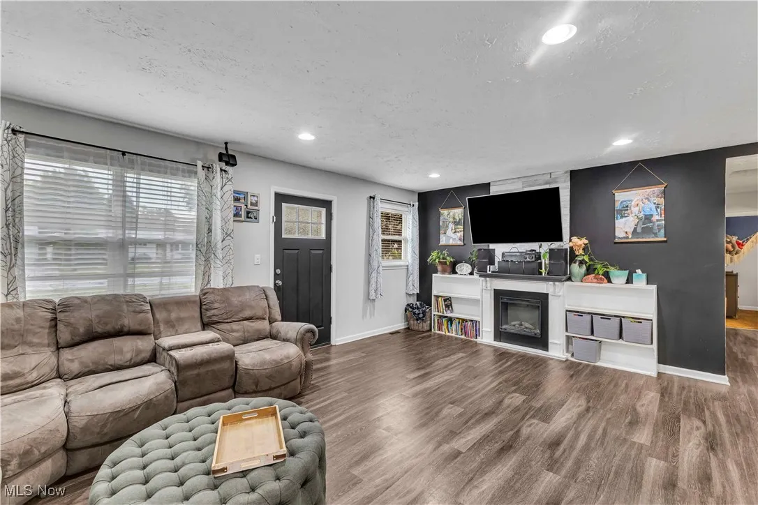 Living area with plenty of natural light, wood finished floors, recessed lighting, and a textured ceiling