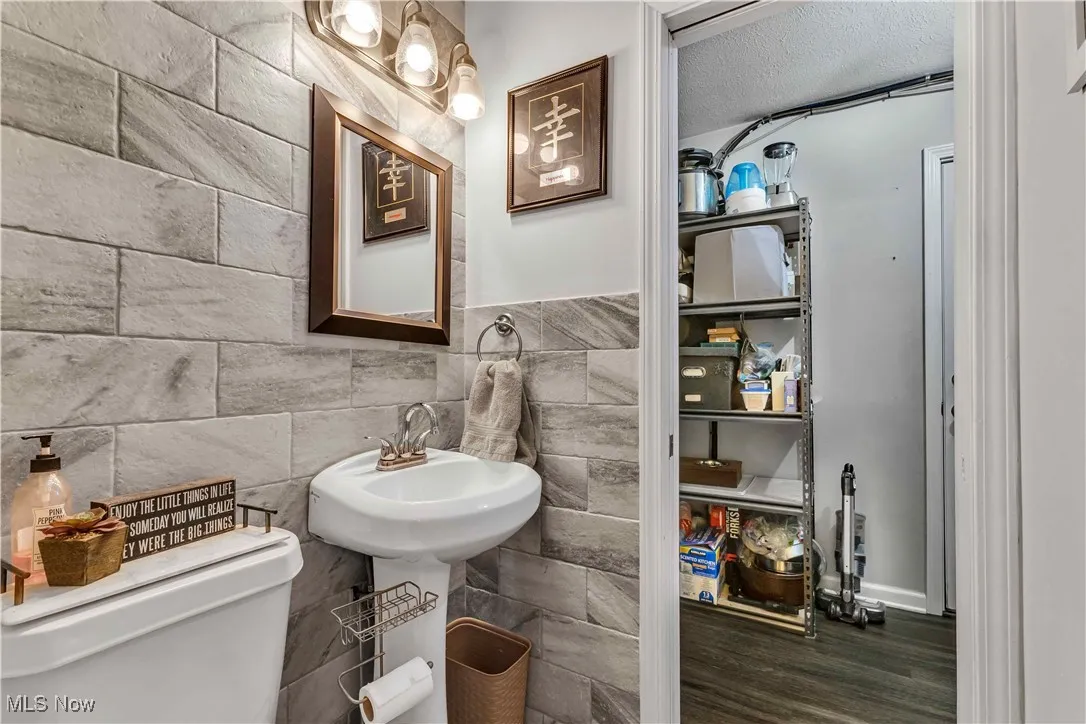 Half bath with dark wood finished floors and a textured ceiling