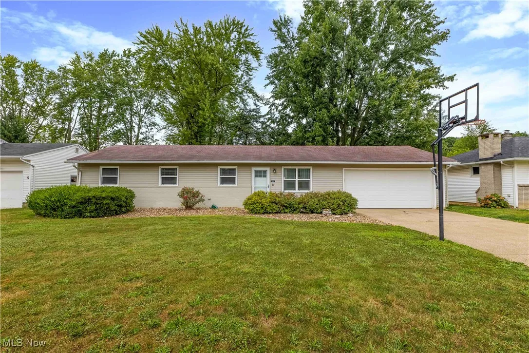 Ranch-style house with an attached garage, a front yard, and concrete driveway