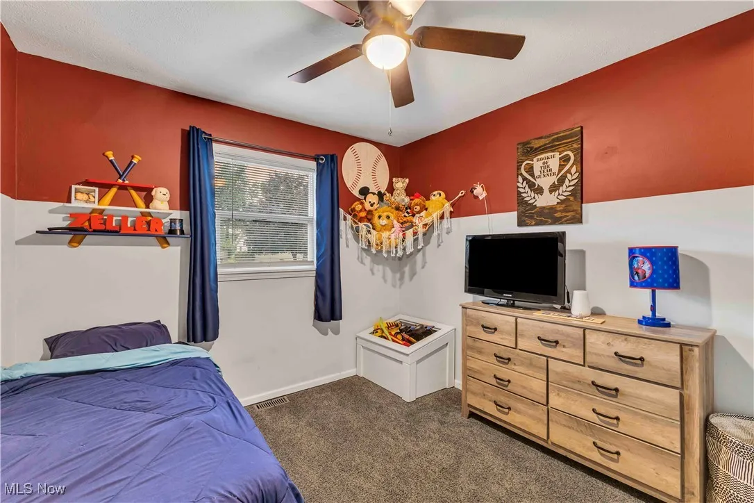 Bedroom with carpet, window, overhead ceiling fan and closet.