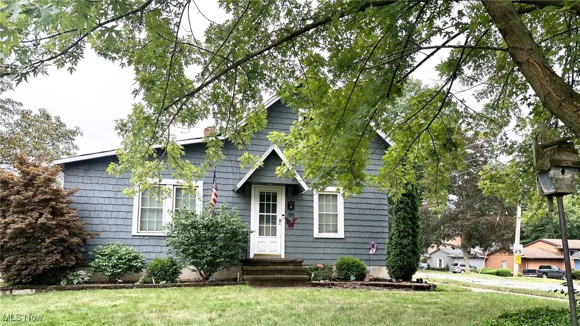 View of front of property with a chimney and a front yard