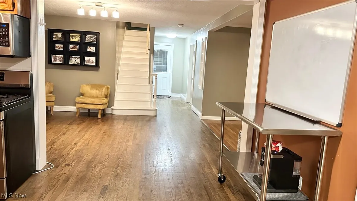 Opening to dining and living room featuring a textured ceiling and light wood floors