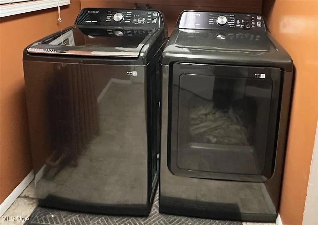 Laundry area with baseboards and washer and clothes dryer
