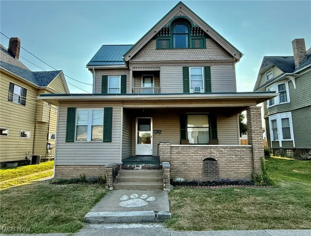 View of front facade featuring a front lawn and a porch